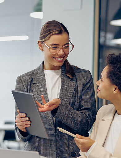 Two women discussing content on a tablet