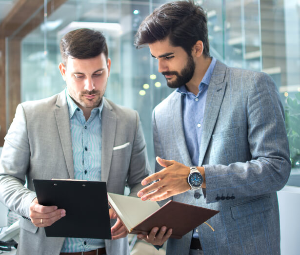 Two men reviewing notes on a clipboard