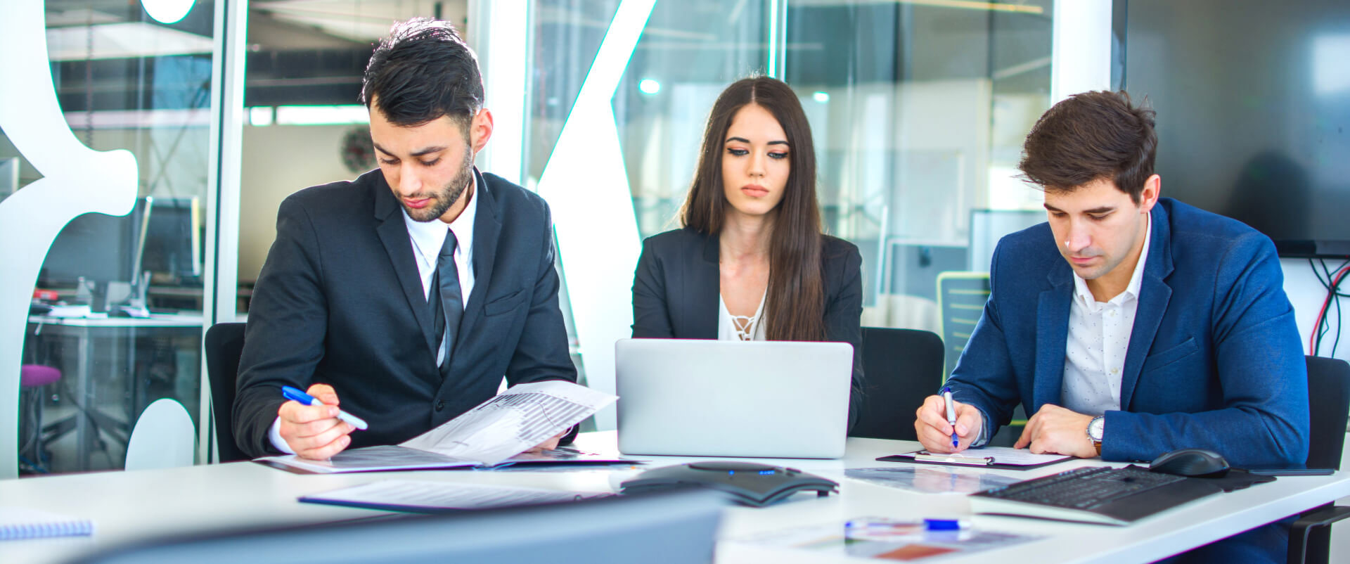Three colleagues working at a table in a modern office